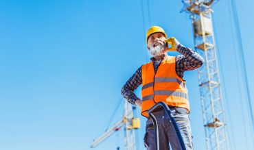 smiling-construction-worker-in-reflective-vest-and-NUZHZRX.jpg