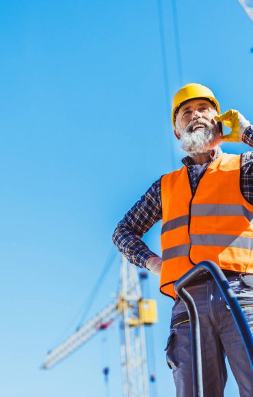 smiling-construction-worker-in-reflective-vest-and-NUZHZRX.jpg